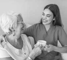 caregiver giving elder woman a cup of tea