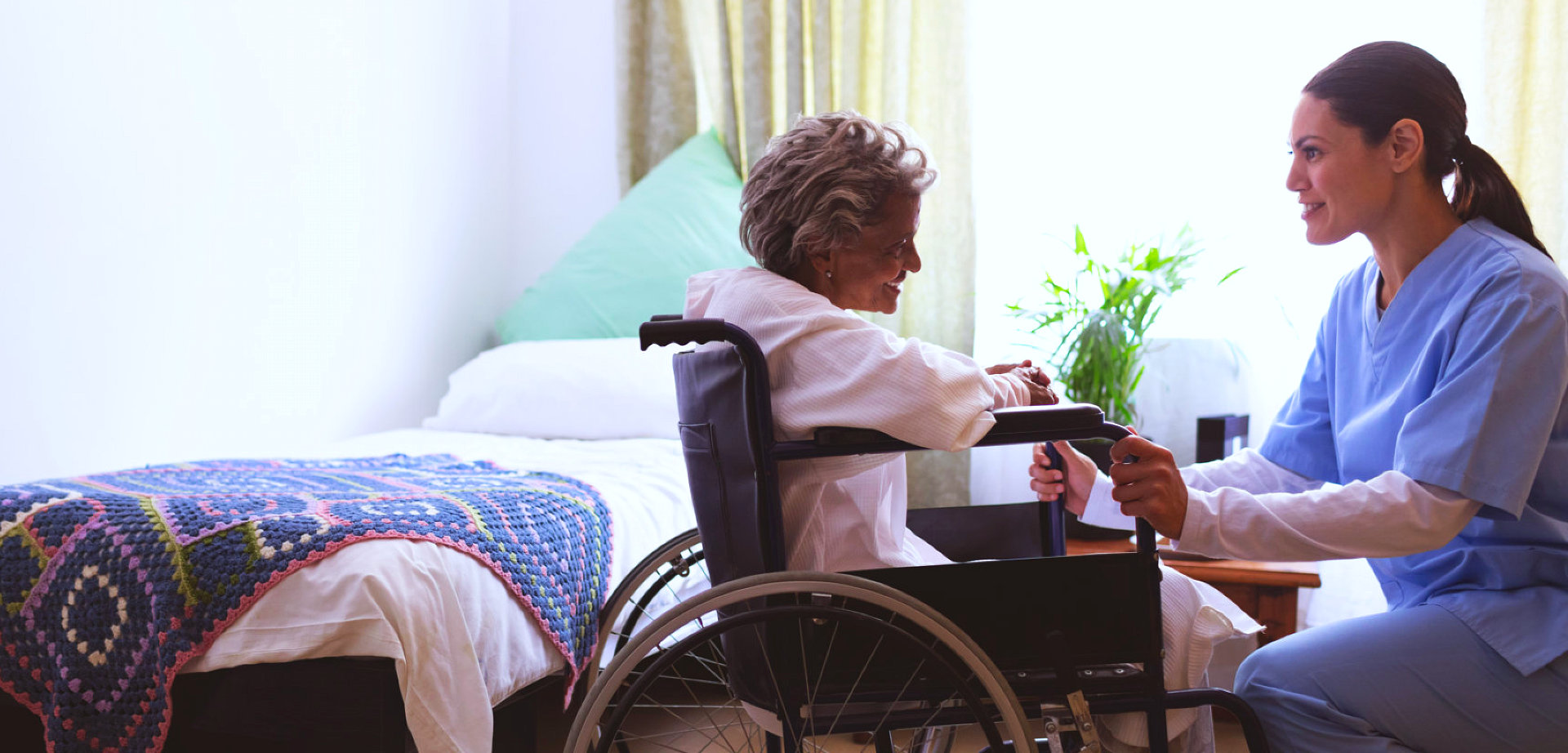 elder woman on a wheelchair with caregiver talking to her