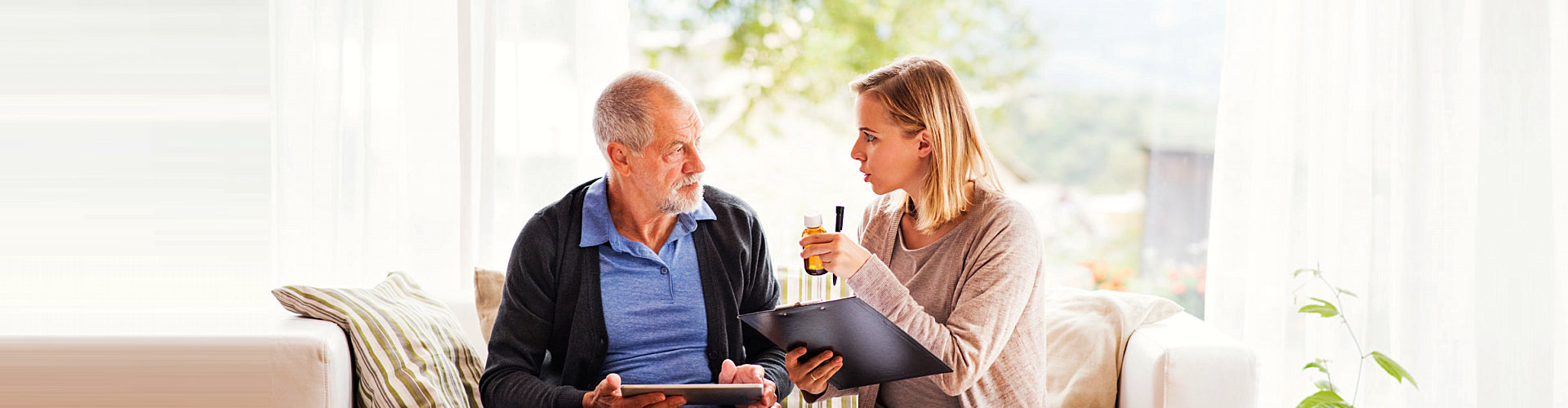 caregiver showing medicine to an elder man