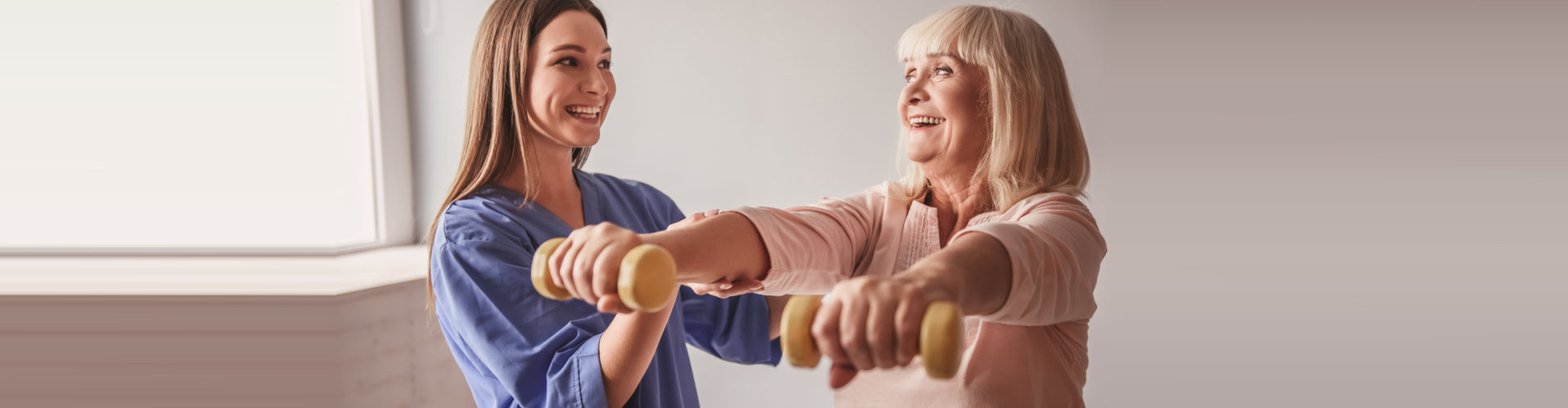 caregiver assisting elder woman in exercising concept