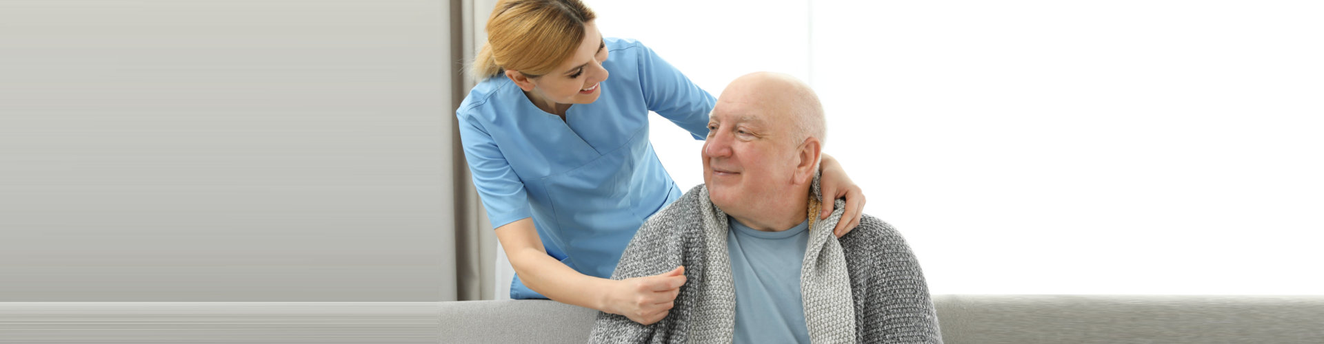 elder man sitting on a couch with caregiver